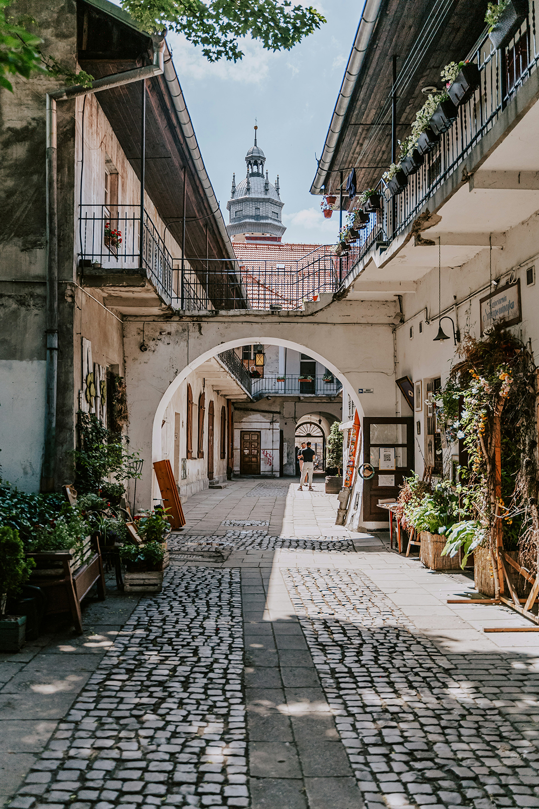 Ulični prehod v Kazimierzu, kjer se zgodovina prepleta z umetnostjo, kavarnami in ustvarjalnim vzdušjem.