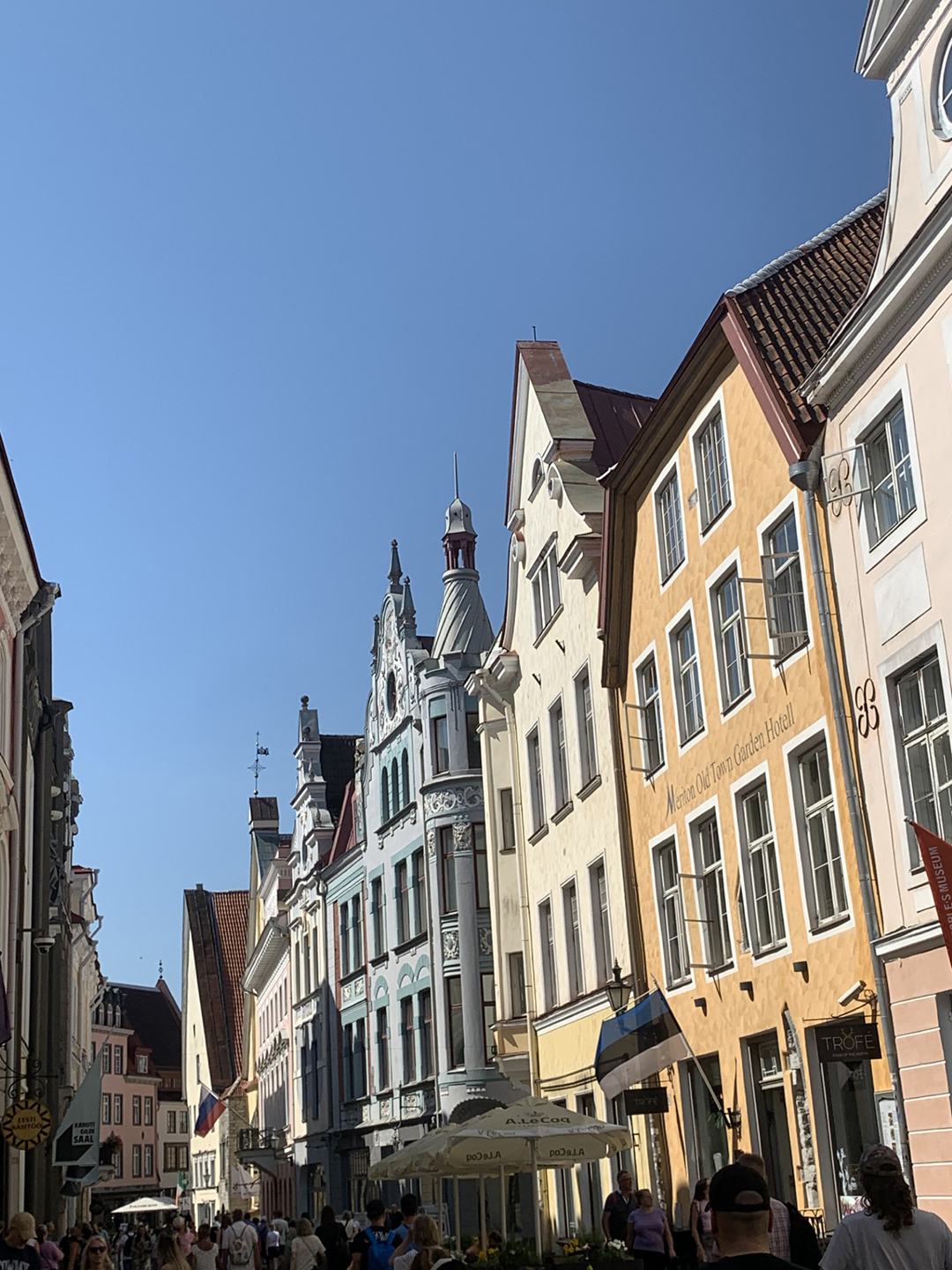 Slikovita ulica starega mestnega jedra Talina, obdana z barvitimi srednjeveškimi hišami in živahnim utripom mesta.