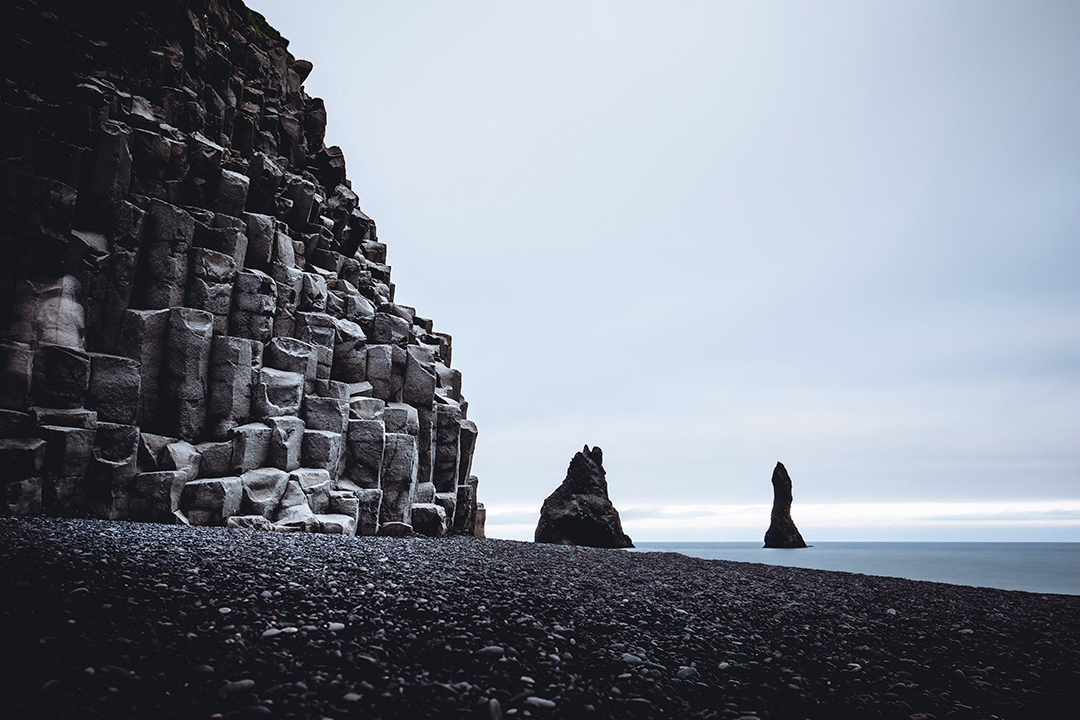 Reynisfjara Black Sand Beach with towering basalt cliffs and sea stacks along Iceland's south coast creates one of the country's most dramatic landscapes.