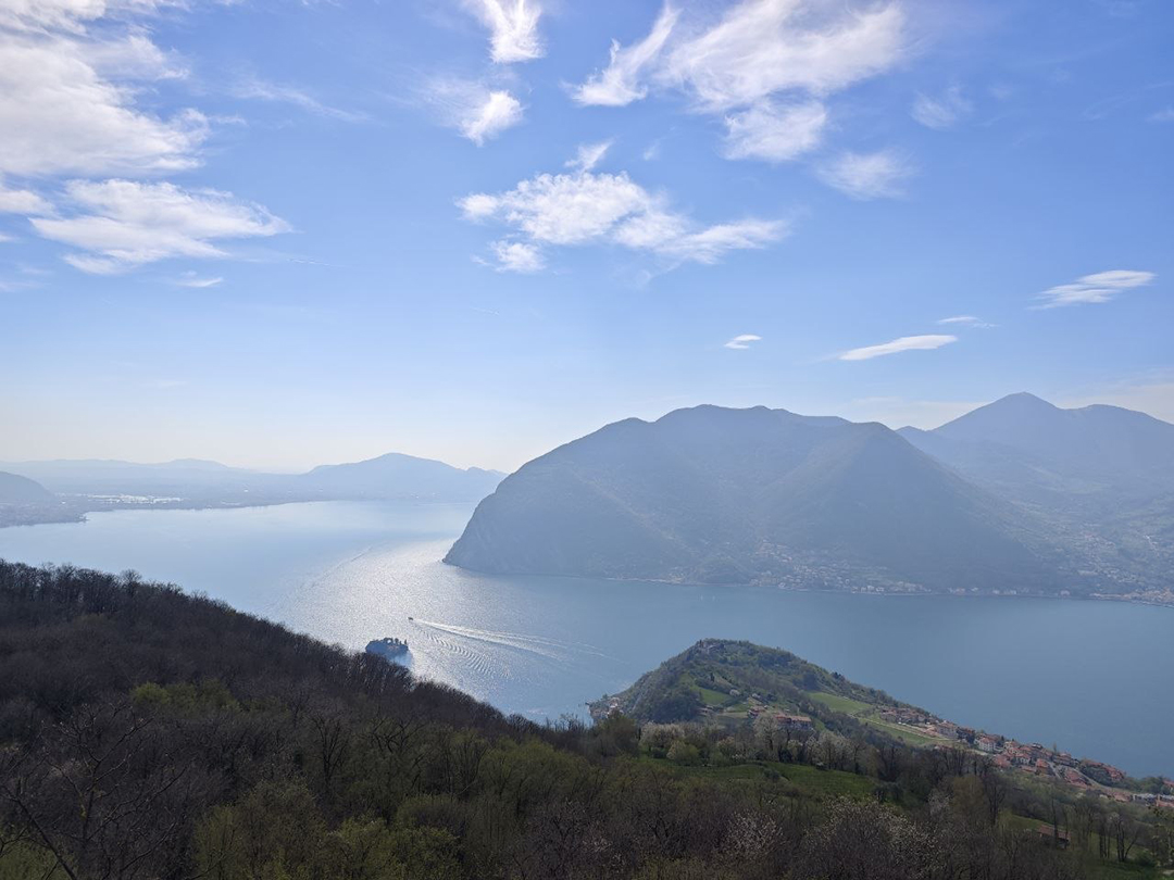 The panoramic view from Santuario della Madonna della Ceriola stretches across Lake Iseo and the surrounding mountains, capturing the peaceful spirit of slow travel in Italy.
