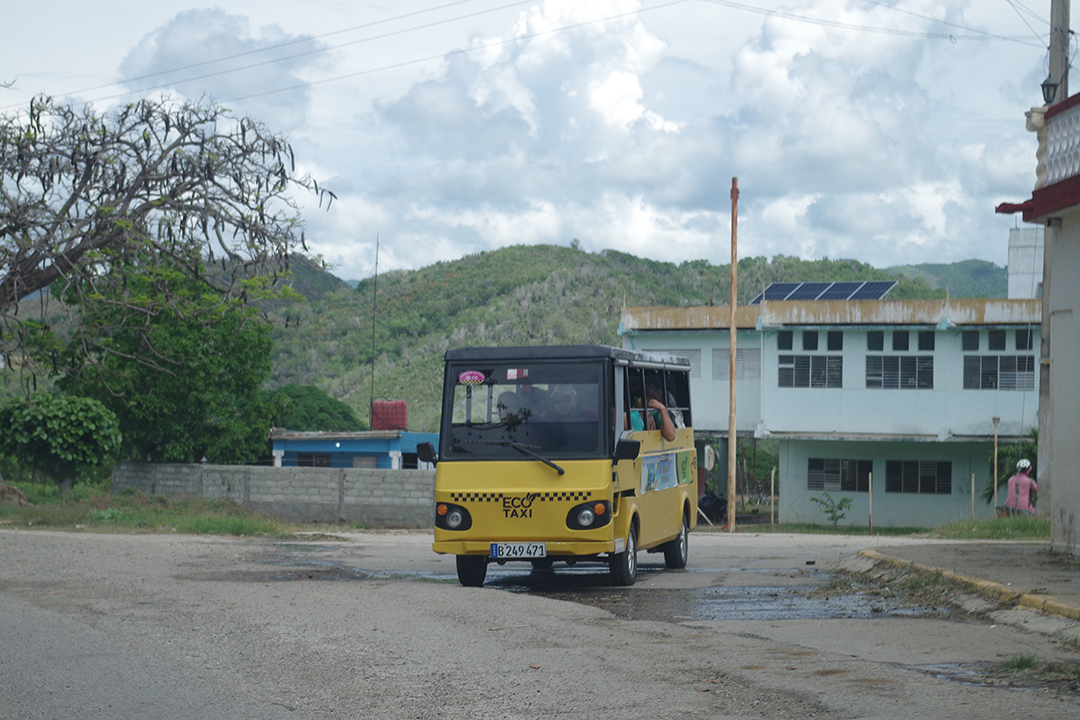 A small Eco Taxi travelling through a Cuban town reflects everyday local transport and the practical ways Cubans adapt to daily mobility across the island.