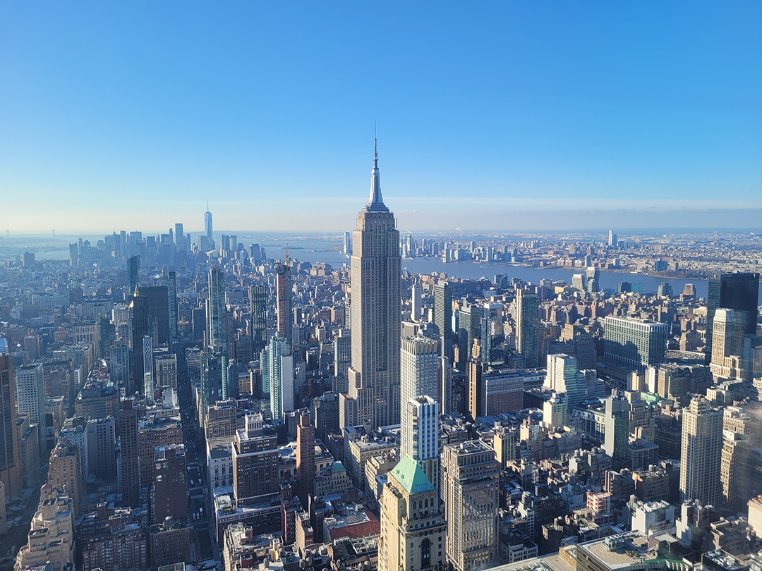 View from the Empire State Building overlooking Manhattan, revealing New York City's iconic skyline, countless skyscrapers and the Hudson River in the distance.