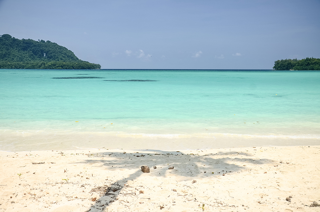 The white sandy beach of Port Olry on Espiritu Santo Island is known for its turquoise sea and peaceful tropical atmosphere.